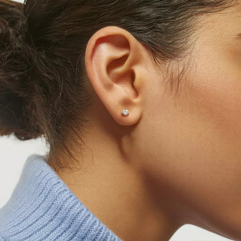 Close-up of an ear wearing a .540cttw diamond stud earring with a blurred background