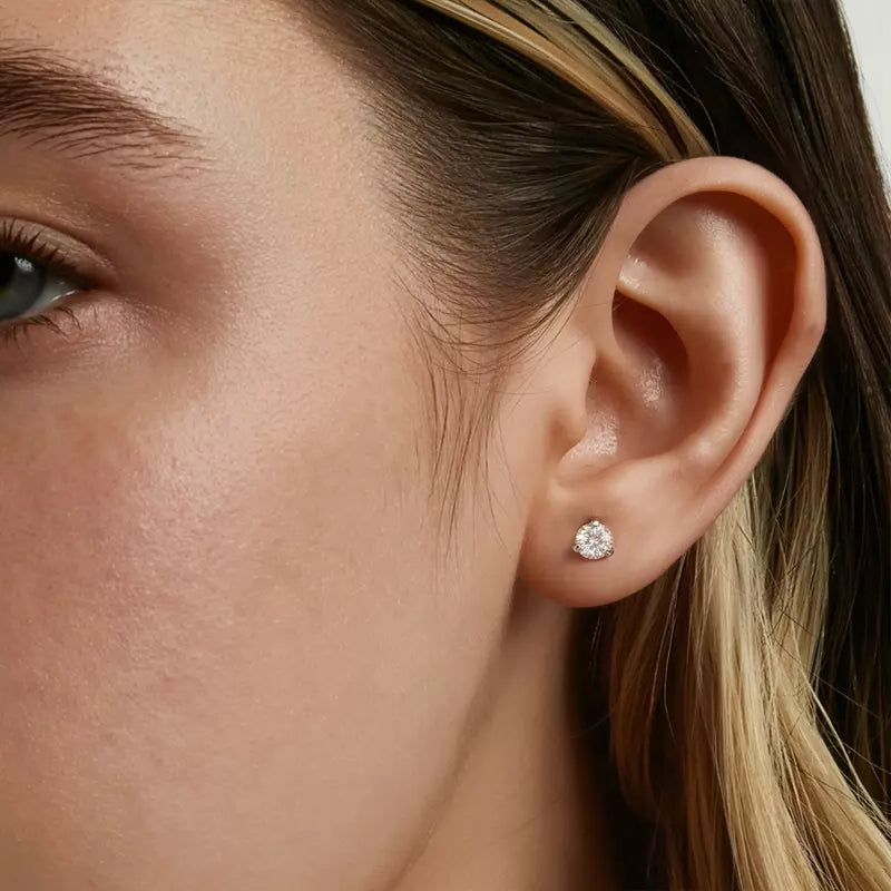 Close-up of a woman's ear wearing a .75cttw diamond stud earring.